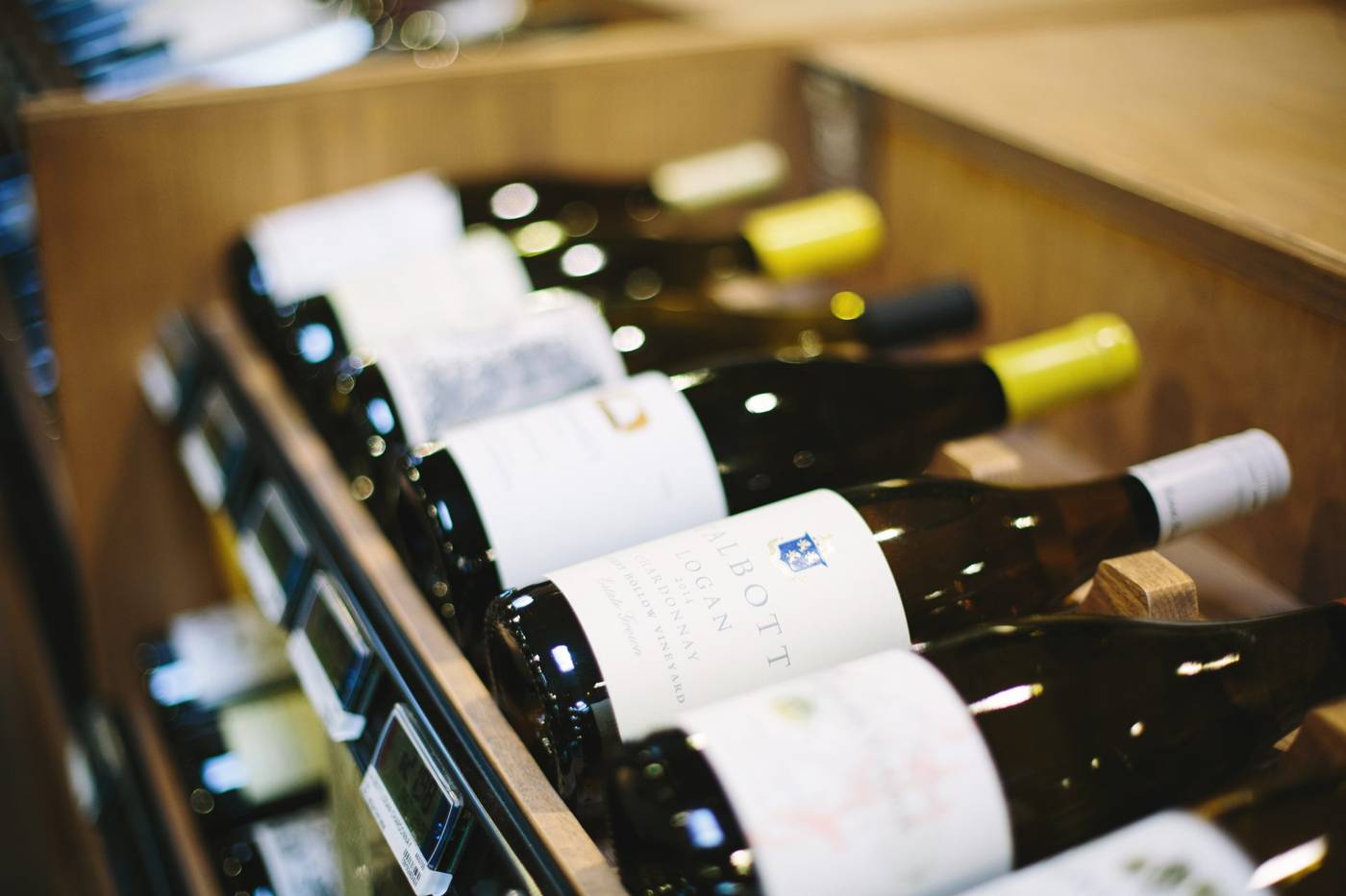 Wine bottles racked on wooden shelves in a real mPower customer store